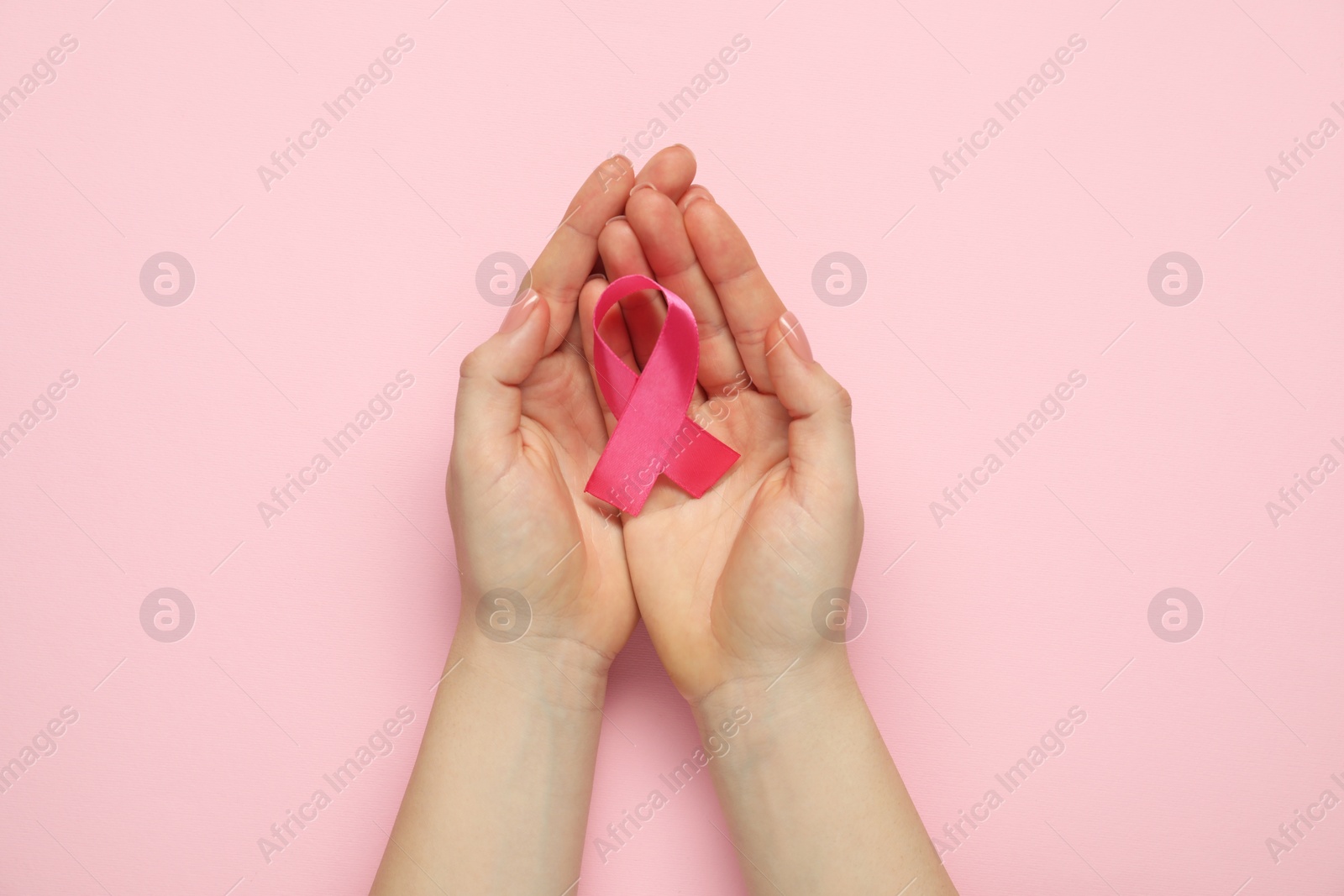 Photo of Woman with pink ribbon on color background, top view. Breast cancer awareness