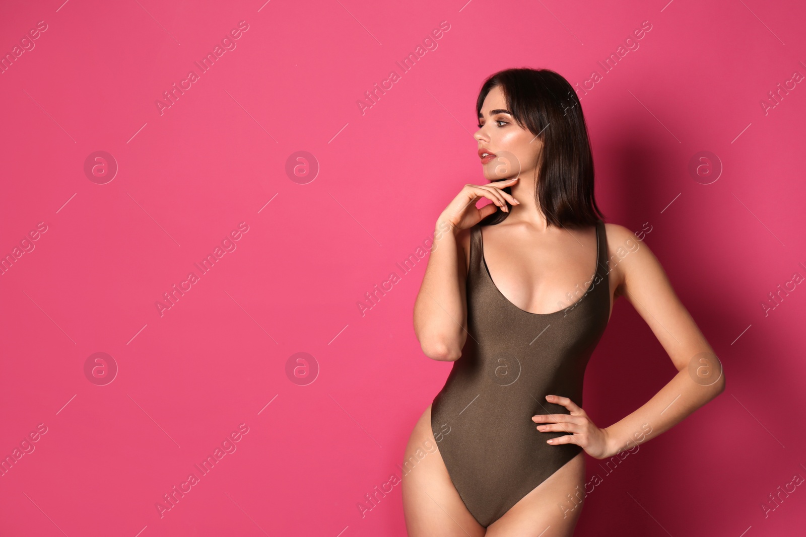 Photo of Beautiful young woman wearing swimsuit on pink background. Space for text