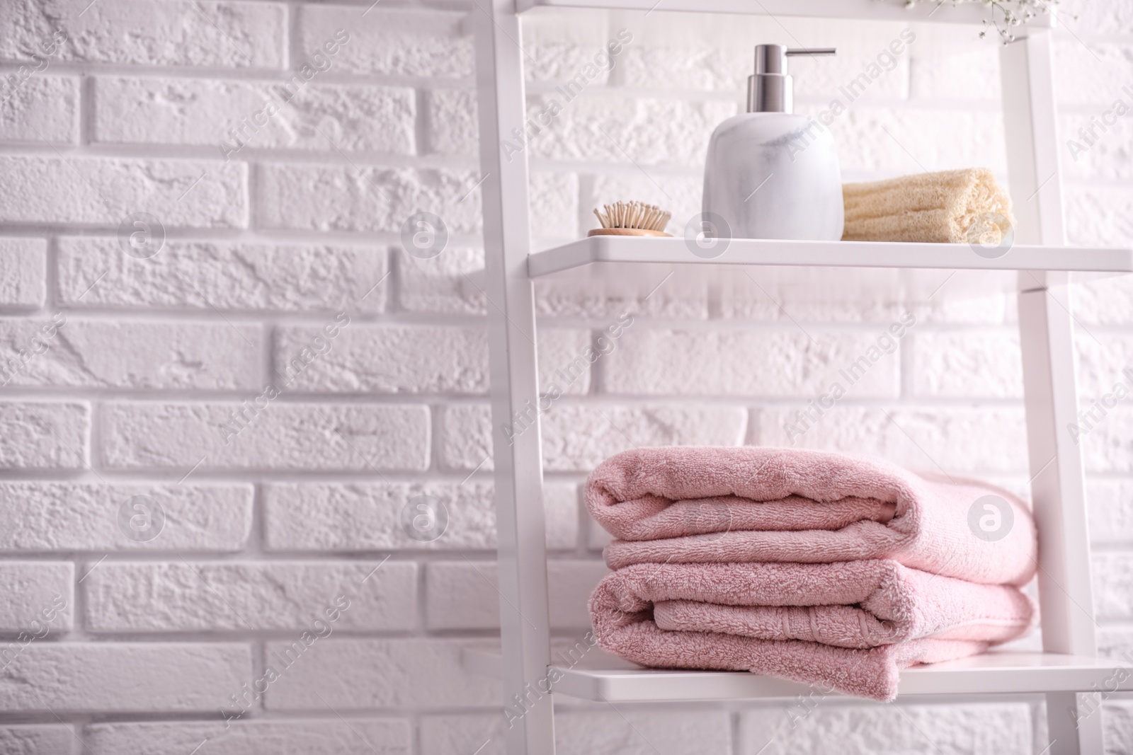 Photo of Clean towels on shelving unit in bathroom. Space for text