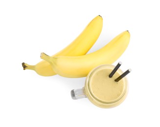 Photo of Mason jar with smoothie and bananas on white background, top view