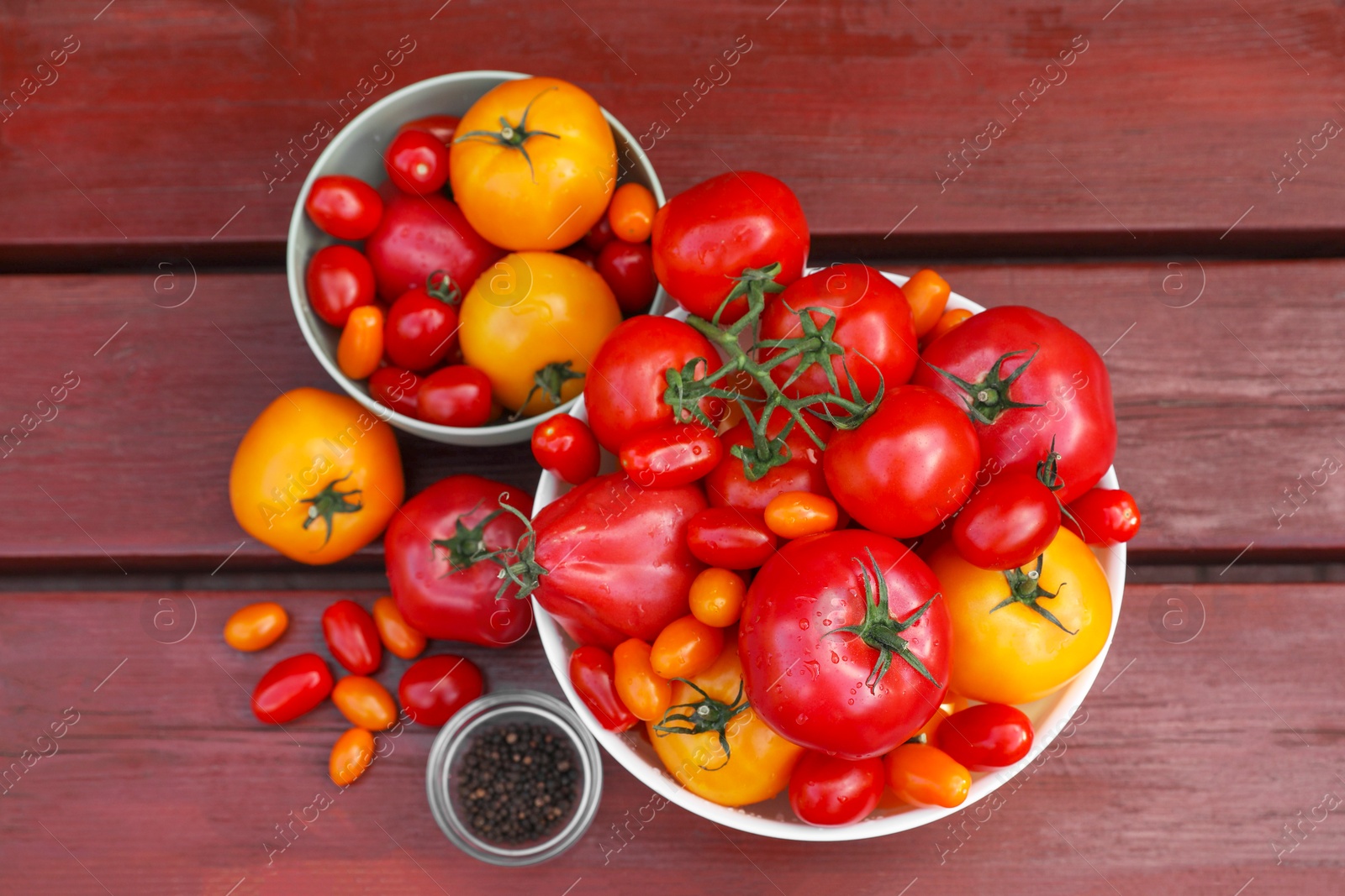 Photo of Bowls with fresh tomatoes and spices on wooden table, flat lay