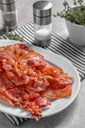 Photo of Plate with fried bacon on table