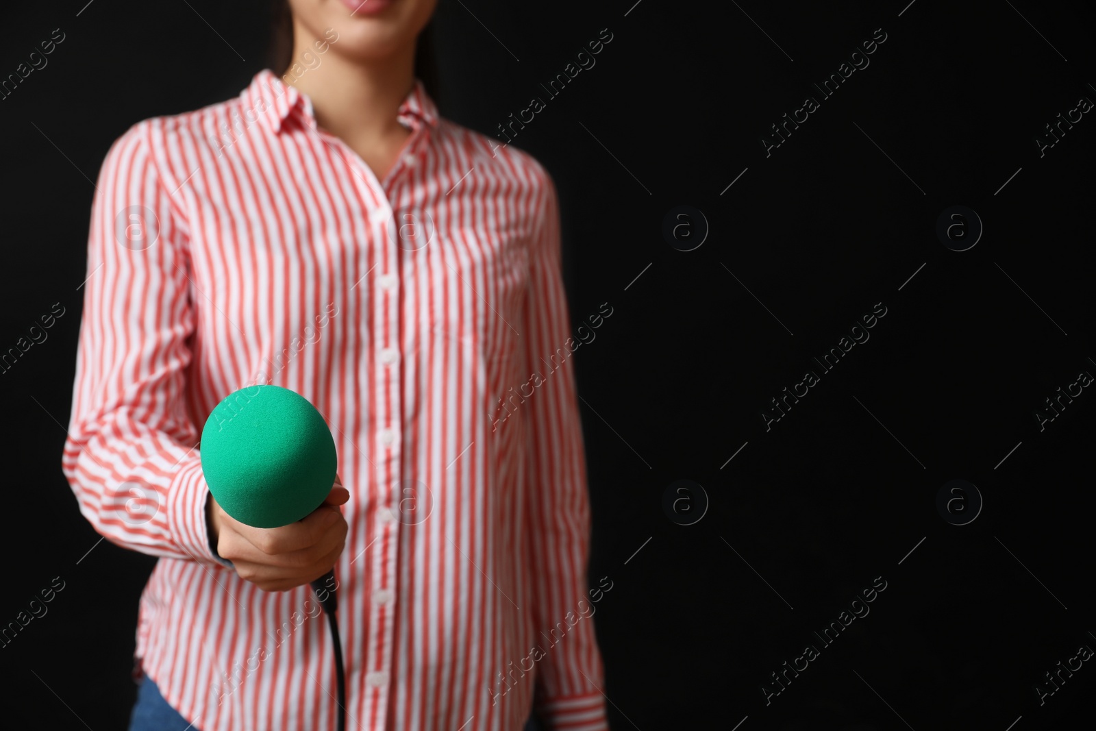 Photo of Journalist with microphone on black background, closeup. Space for text