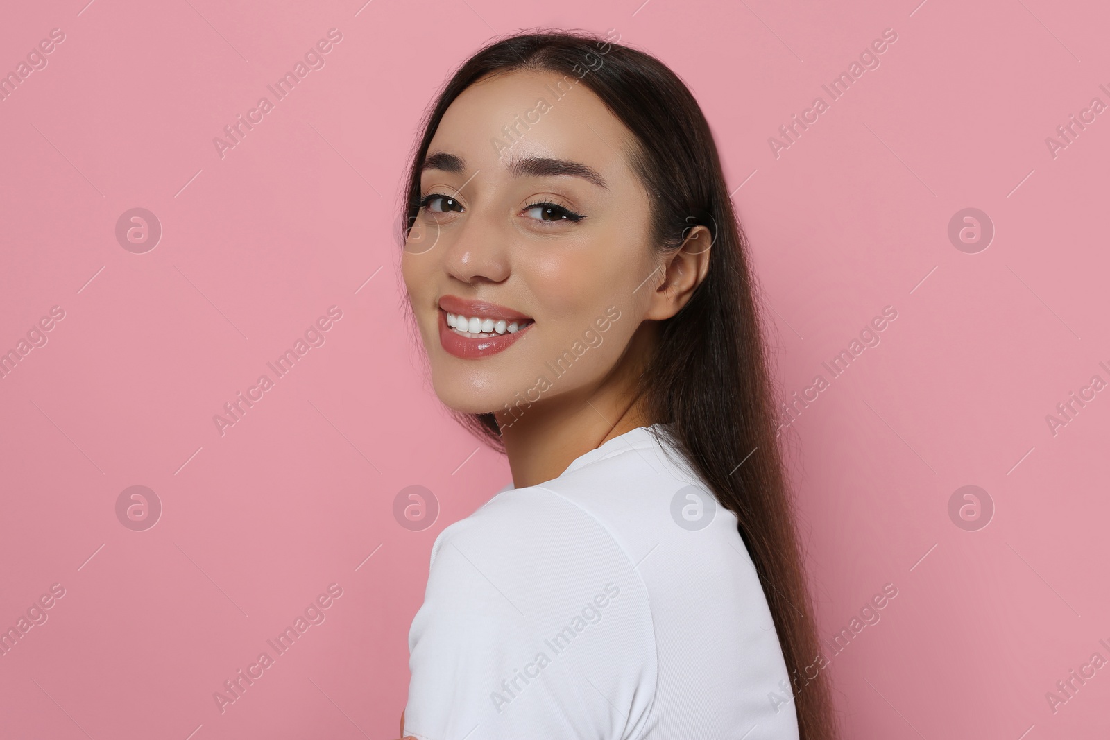 Photo of Portrait of beautiful young woman with elegant makeup on pink background