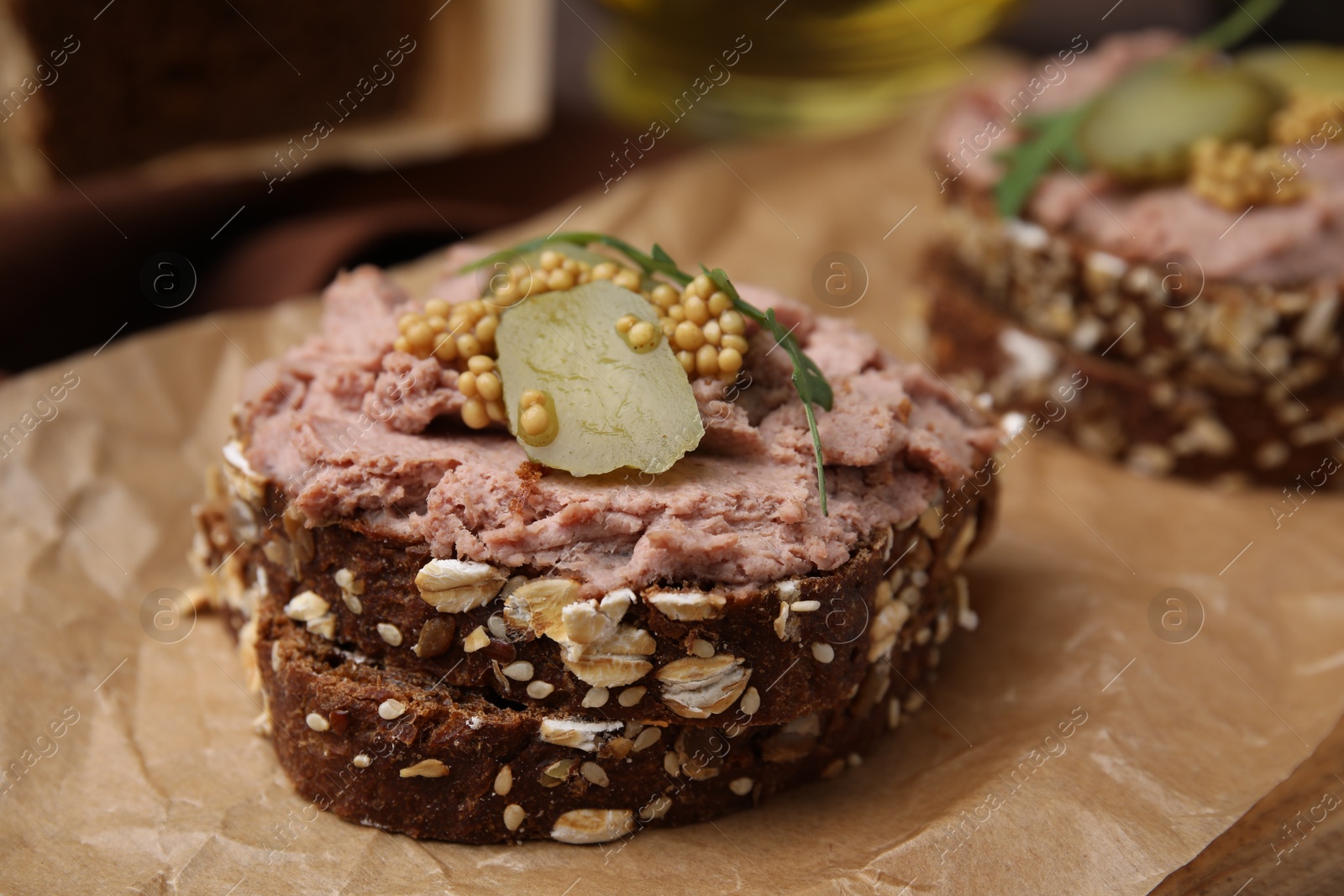 Photo of Delicious liverwurst sandwiches with pickled cucumber and mustard on table, closeup