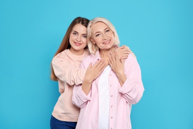 Photo of Portrait of mature woman and her daughter on color background