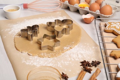 Photo of Making Christmas cookies. Ingredients, cutters and raw dough on white table