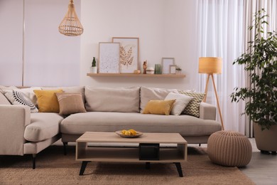 Stylish living room interior with comfortable grey sofa and coffee table