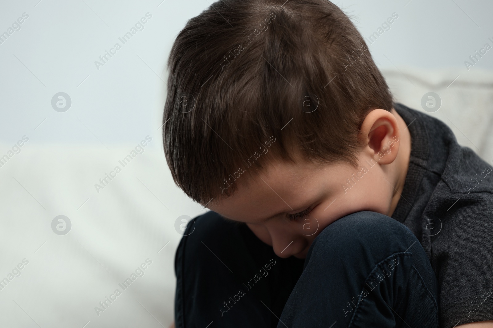 Photo of Sad little boy on sofa at home