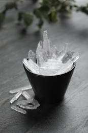 Menthol crystals in bowl on grey background