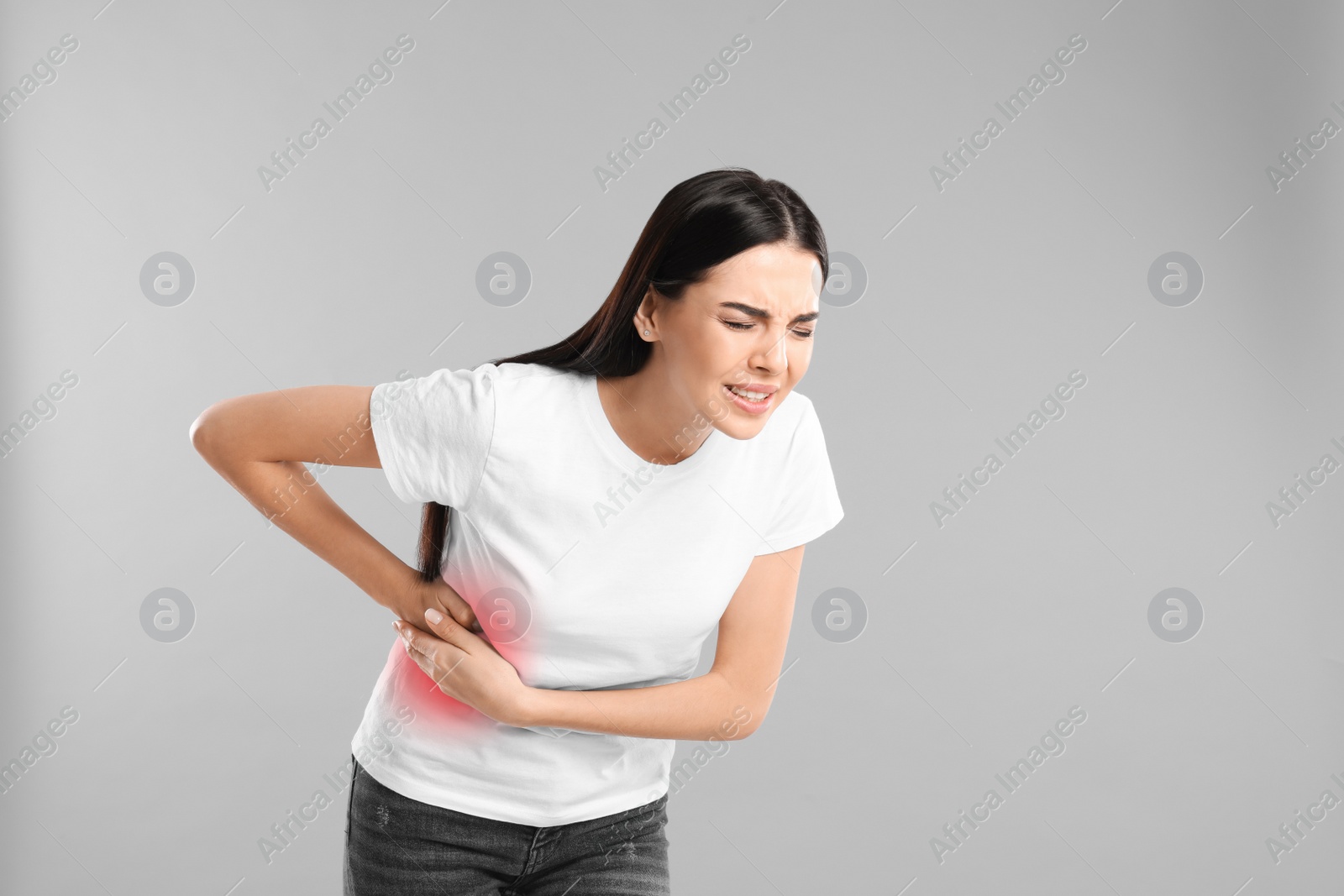 Photo of Woman suffering from liver pain on grey background