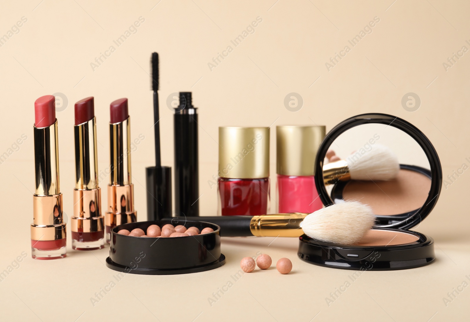 Photo of Different luxury decorative cosmetics and brush on beige background