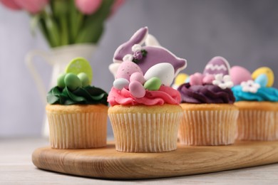 Tasty decorated Easter cupcakes on wooden table