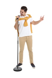 Photo of Young handsome man in casual clothes singing with microphone on white background