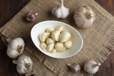 Fresh garlic bulbs and cloves on wooden table, flat lay