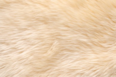 Photo of Texture of beige faux fur as background, top view