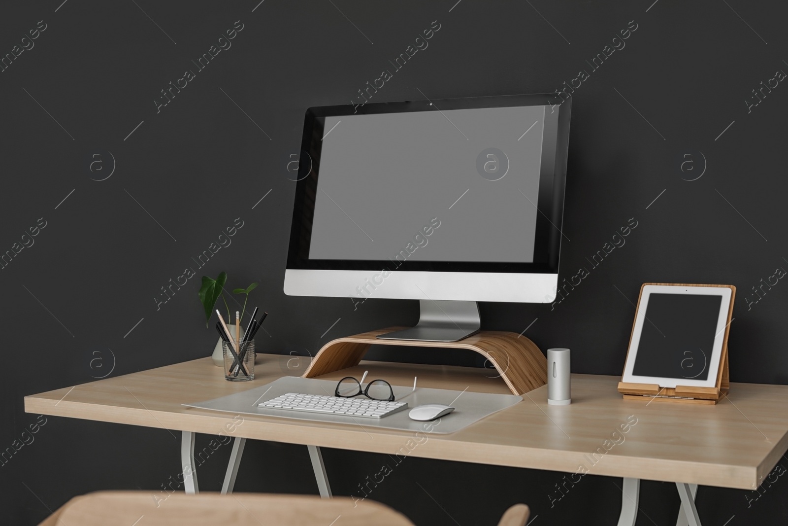 Photo of Modern workplace interior with computer on table. Space for text