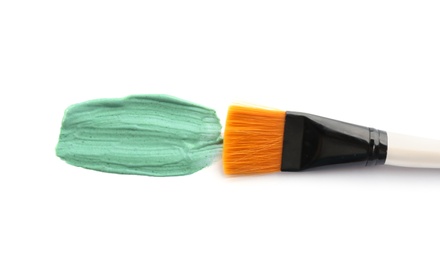 Photo of Spirulina facial mask smeared with makeup brush on white background