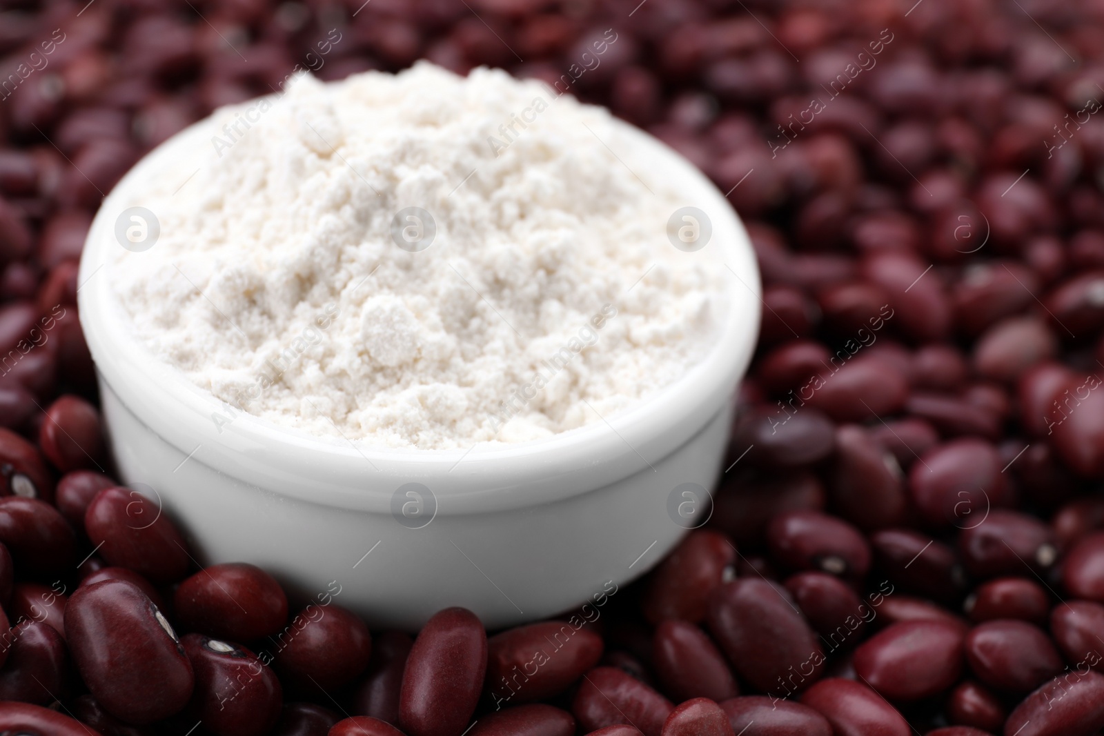 Photo of Bowl with kidney bean flour on brown seeds, closeup. Space for text