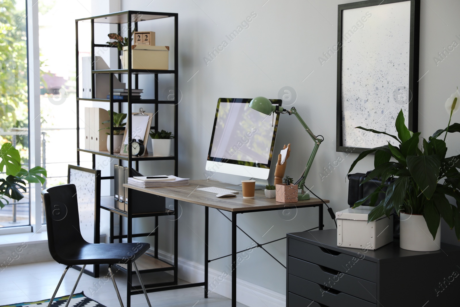 Photo of Comfortable office chair near desk with modern computer indoors