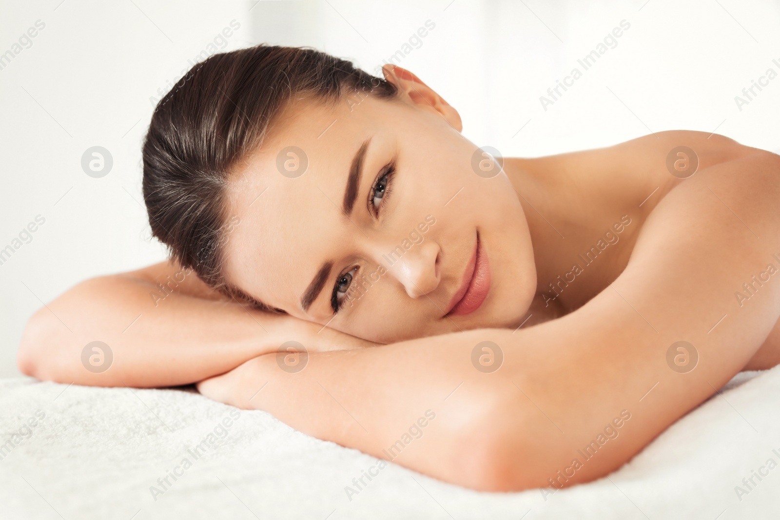 Photo of Young woman lying on massage table in spa salon