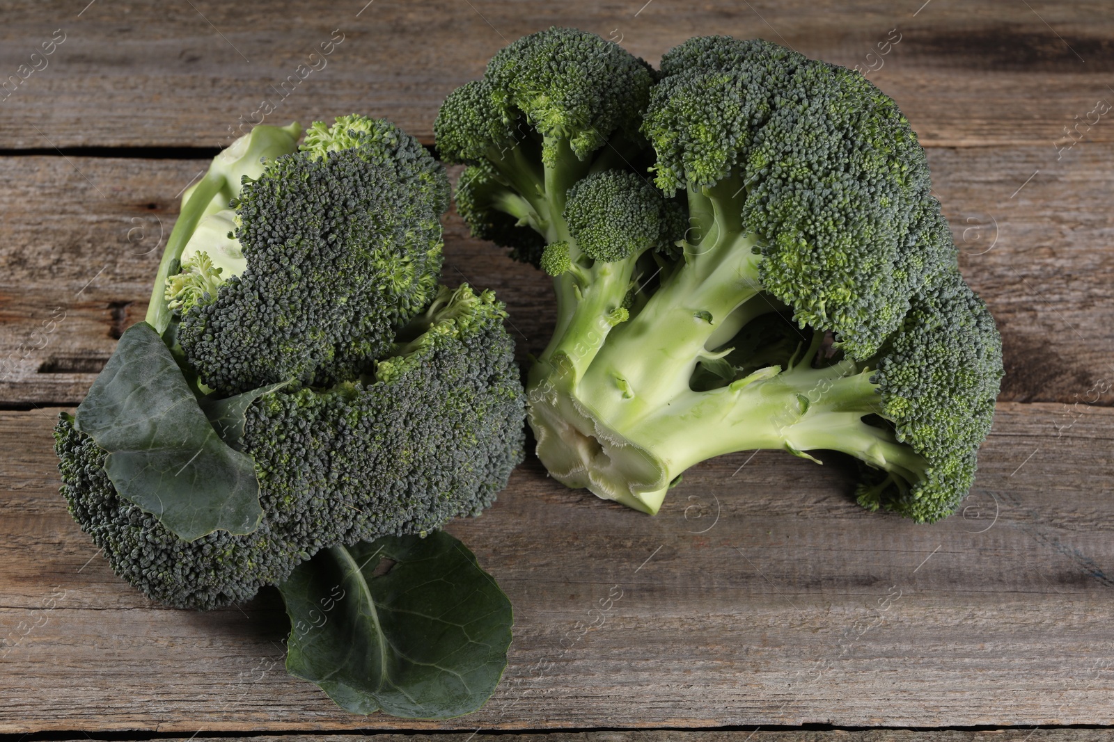 Photo of Fresh raw broccoli on wooden table, closeup