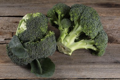 Photo of Fresh raw broccoli on wooden table, closeup