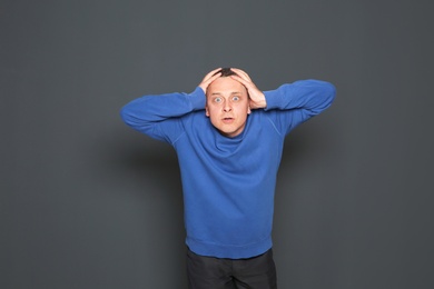 Portrait of emotional mature man on dark background