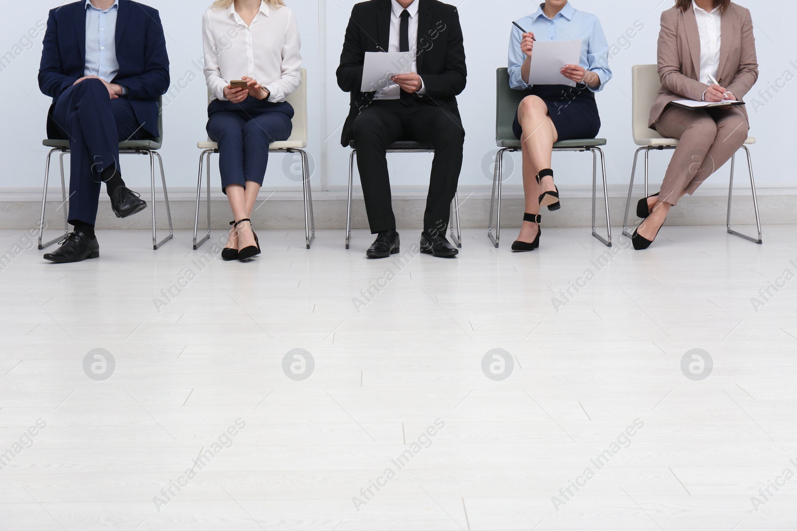 Photo of People waiting for job interview in office hall, closeup