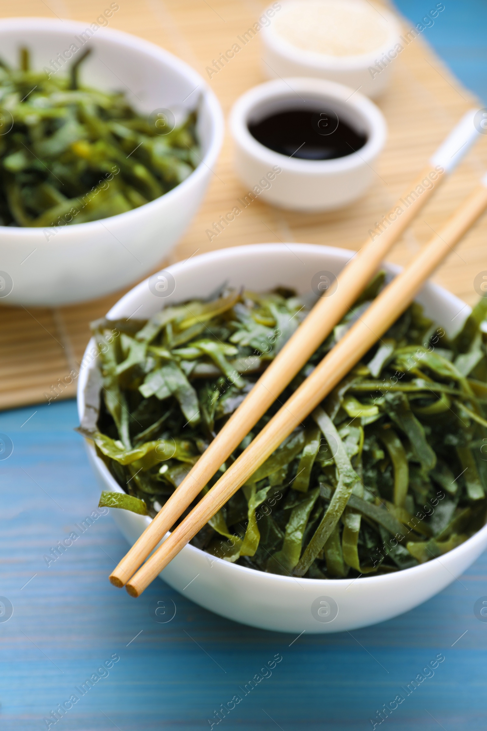 Photo of Fresh laminaria (kelp) seaweed served on light blue wooden table