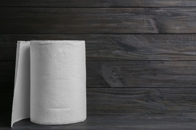 Photo of Roll of paper towels on wooden table, space for text