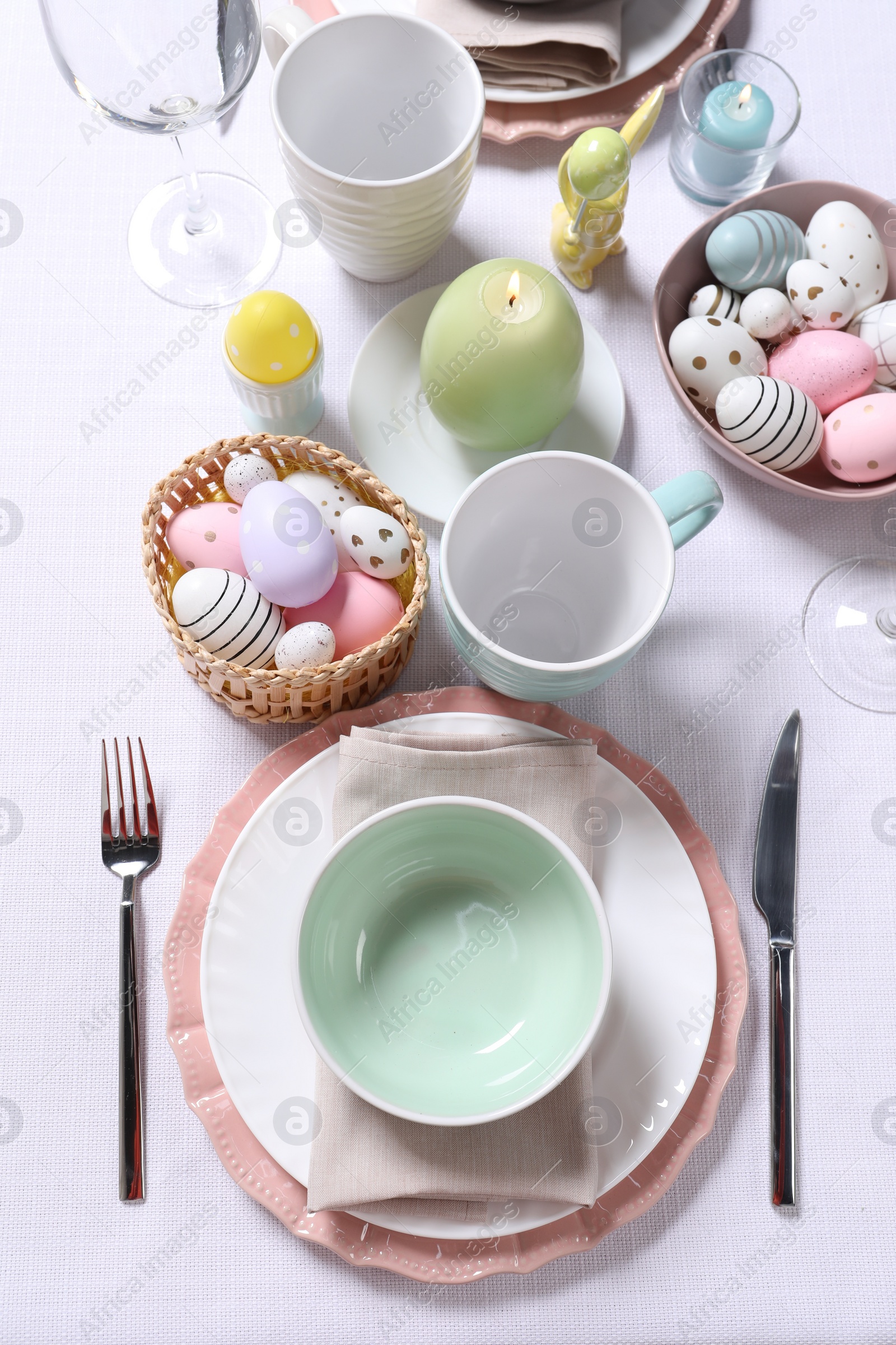 Photo of Festive table setting with painted eggs. Easter celebration