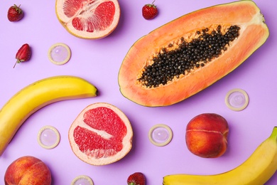 Photo of Flat lay composition with condoms and exotic fruits on lilac background. Erotic concept