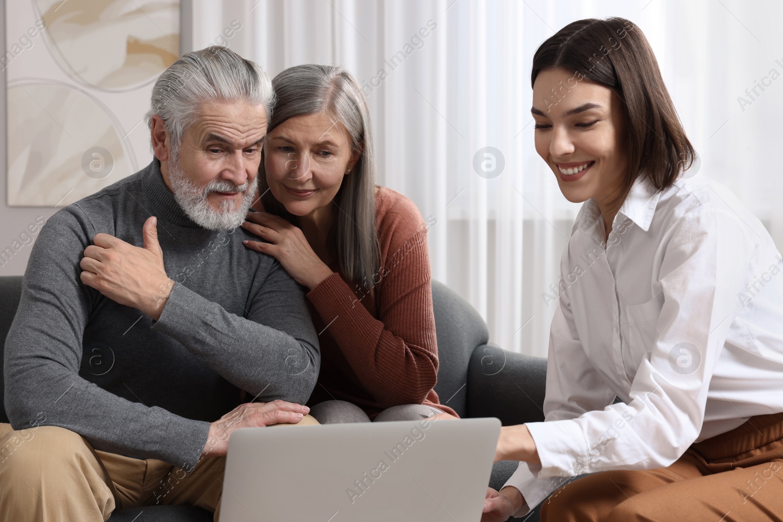 Photo of Insurance agent consulting elderly couple about pension plan in room