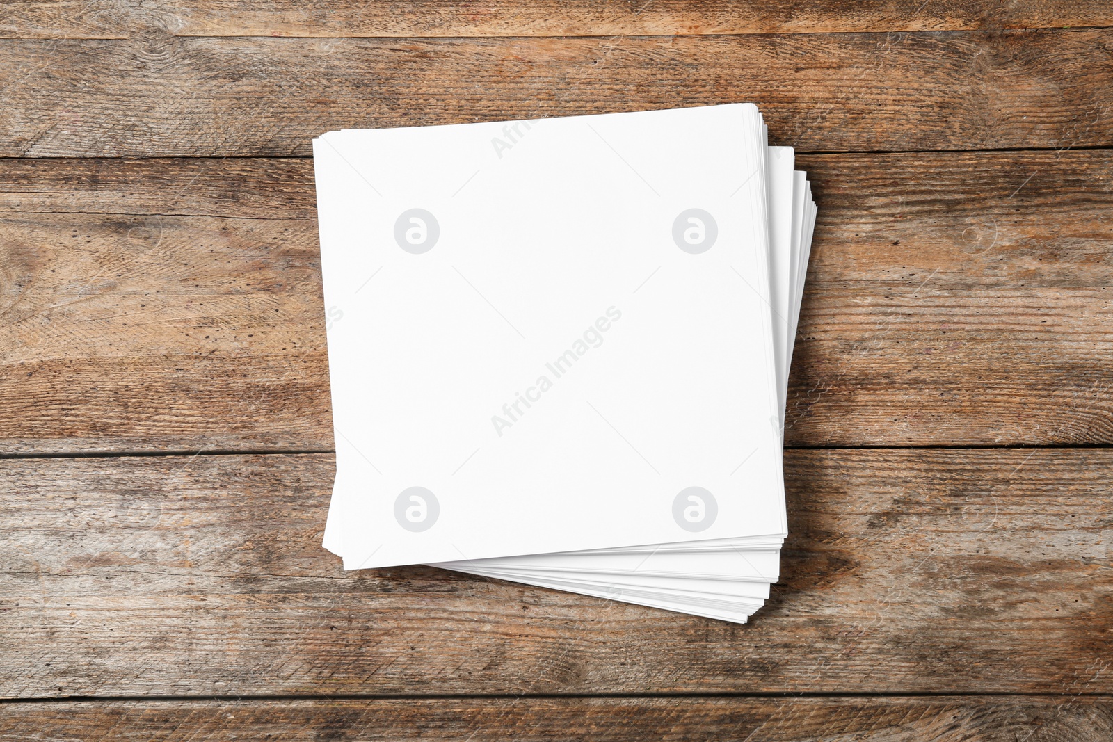 Photo of Stack of blank paper sheets for brochure on wooden background, top view. Mock up