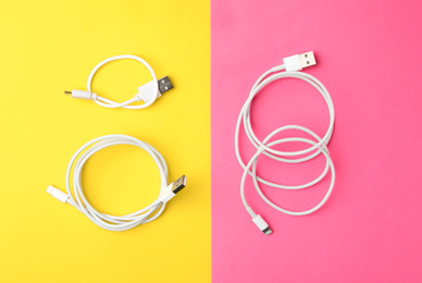 USB charge cables on color background, flat lay
