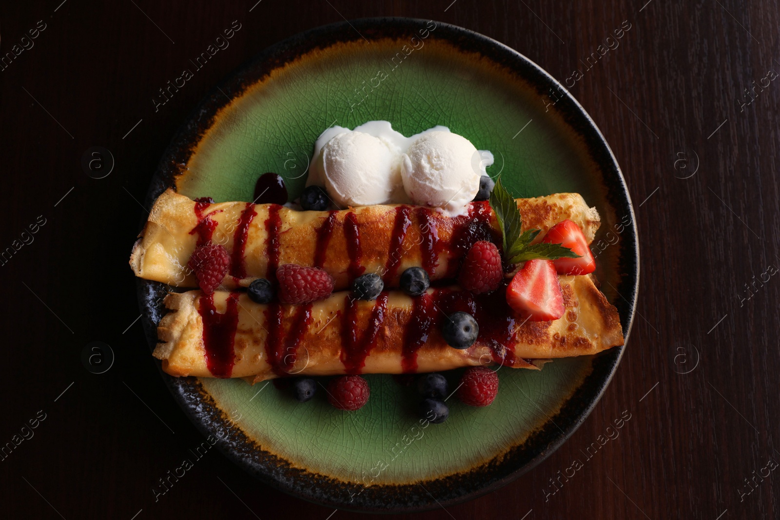 Photo of Delicious pancakes with fresh berries and ice cream on wooden table, top view