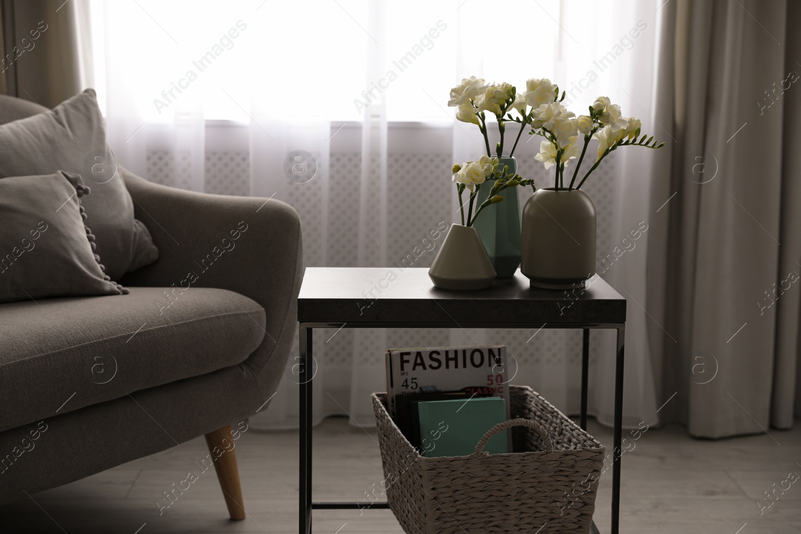 Photo of Beautiful spring freesia flowers on table in room