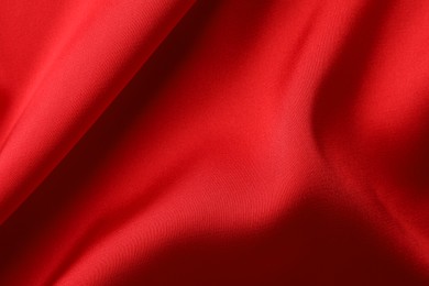 Photo of Crumpled red silk fabric as background, top view