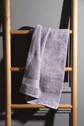 Photo of Soft terry towel on wooden ladder indoors