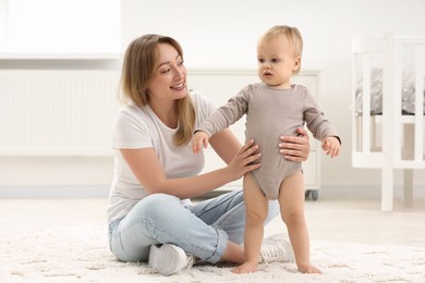 Mother with her little son on rug at home