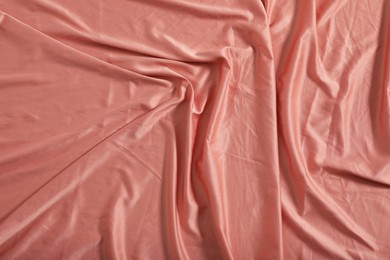 Crumpled coral fabric as background, top view