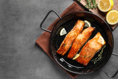 Photo of Dish with tasty cooked salmon on table, top view