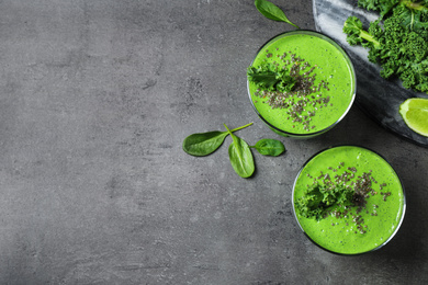 Photo of Tasty kale smoothie on grey table, flat lay. Space for text