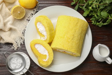 Delicious cake roll, lemons, mint and powdered sugar on wooden table, flat lay
