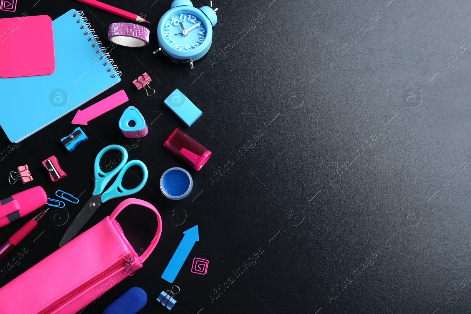 Photo of Different bright school stationery on black background, flat lay. Space for text