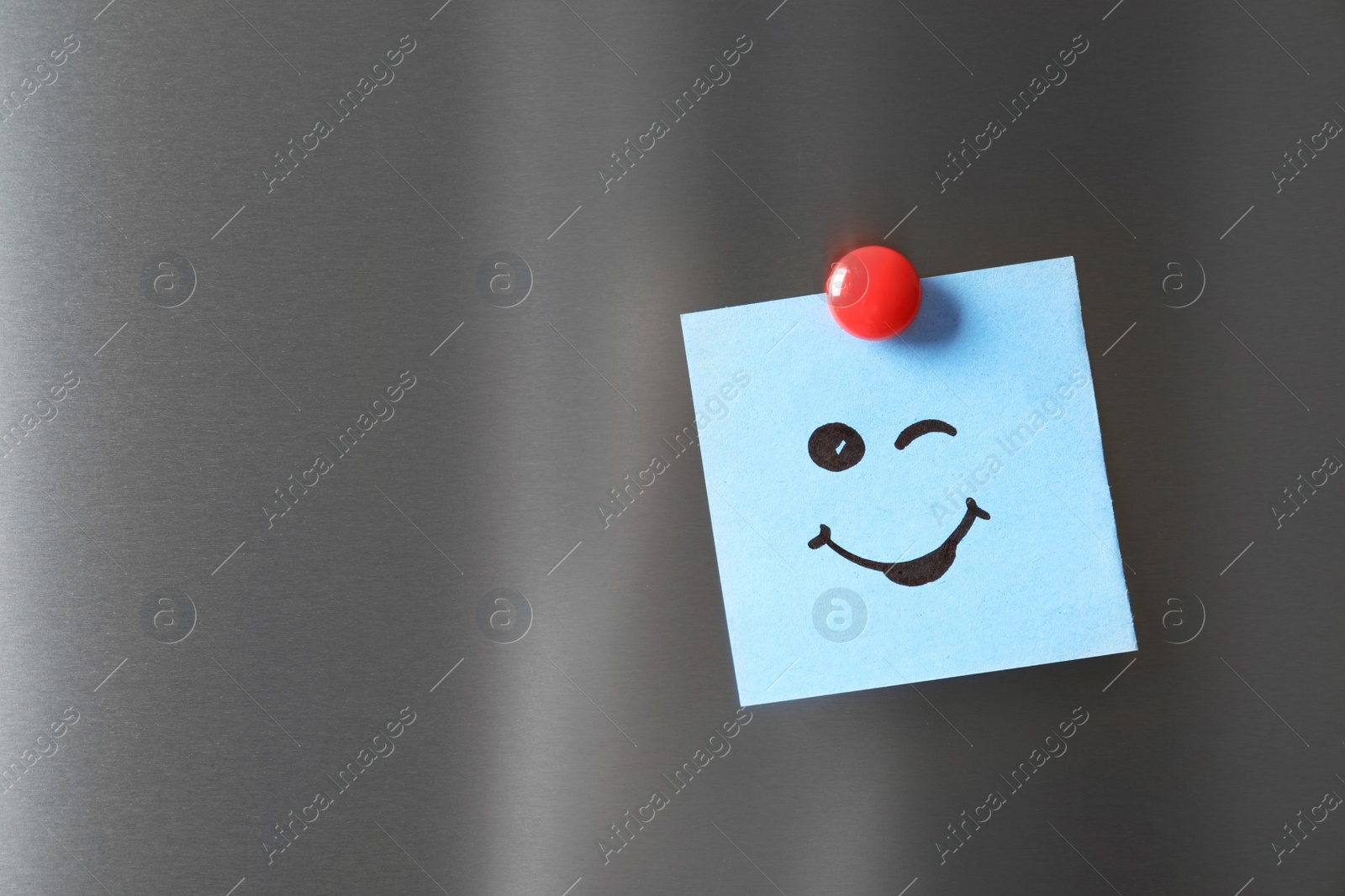 Photo of Note with funny face on refrigerator door. Space for text