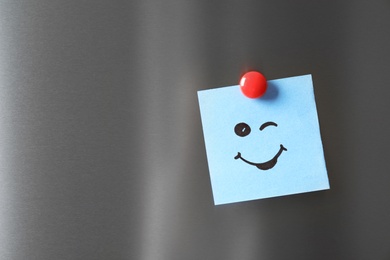 Photo of Note with funny face on refrigerator door. Space for text