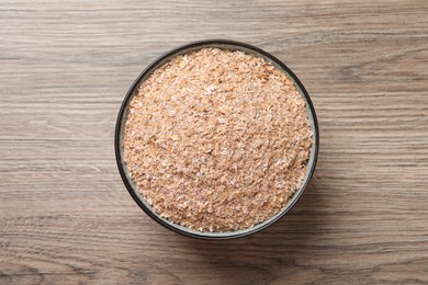 Wheat bran on wooden table, top view