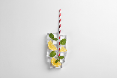 Photo of Creative lemonade layout with lemon slices, straw, ice cubes and mint on white background, top view